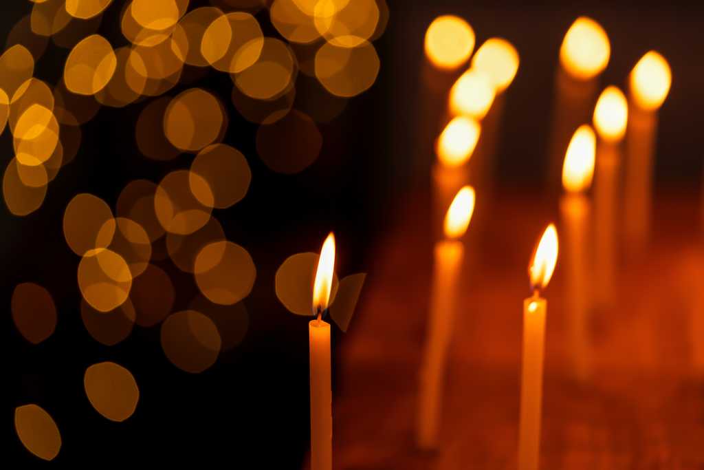 holiday candles lit and reflecting against a black background