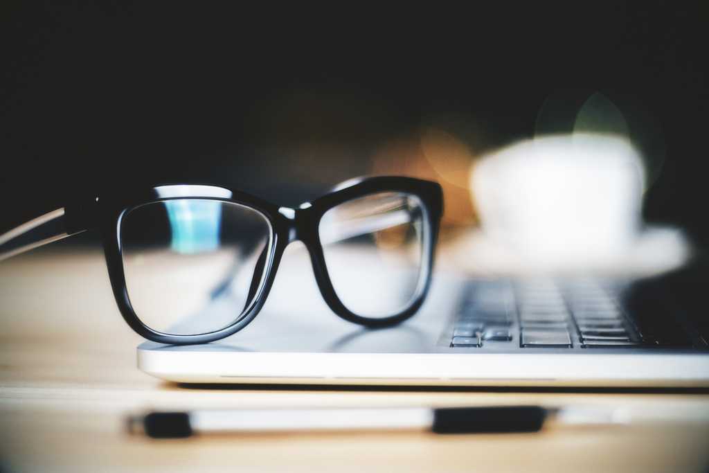 eyeglasses perched on a laptop