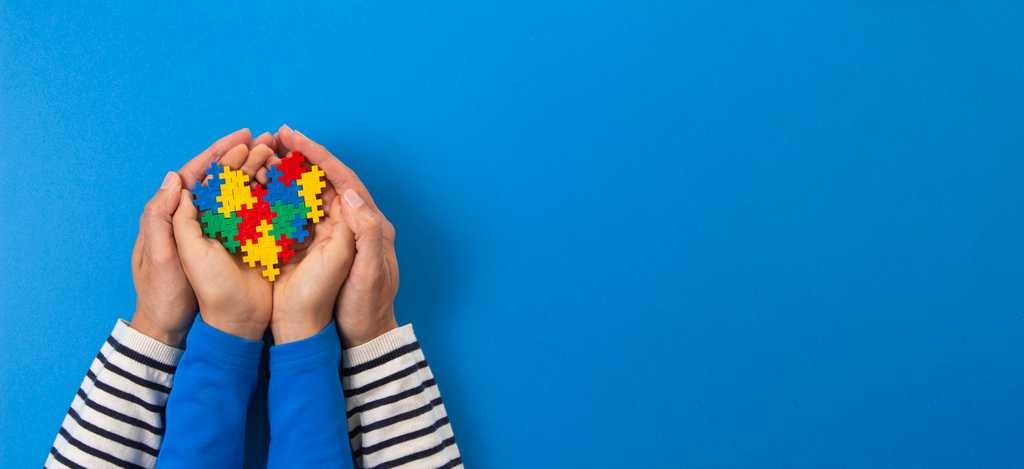 hands holding colorful puzzle heart