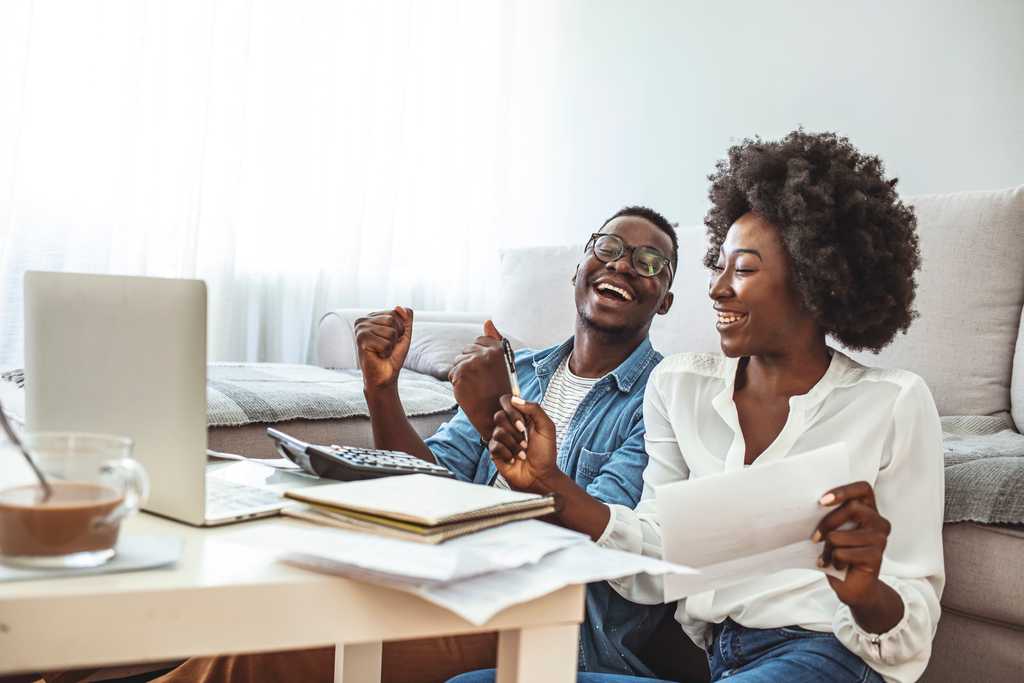 two happy people working at a computer 