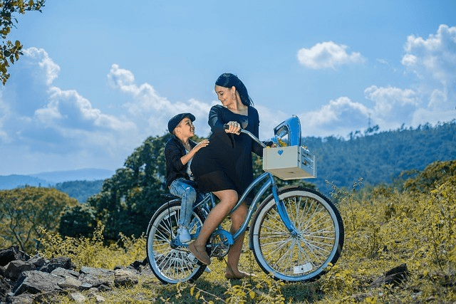 Woman riding a bike with child in moutainscape